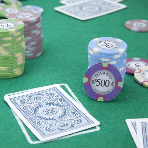 Claysmith Milano poker chips and playing cards on a green felt table